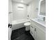 Modern bathroom with black marble floors, white tiles, a shower-tub combo, and a white vanity at 714 Sedge Way, Lafayette, CO 80026