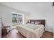 Cozy bedroom featuring a large window, hardwood floors, a comfortable bed, and a reading chair at 714 Sedge Way, Lafayette, CO 80026