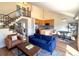 Open floor plan showcasing a modern kitchen, living room with blue sofa, and staircase with metal railings at 714 Sedge Way, Lafayette, CO 80026