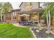Backyard patio with stone pavers, outdoor seating, dining table, and stainless steel grill at 5390 S Geneva St, Englewood, CO 80111