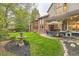 Landscaped backyard with patio, outdoor dining set, lush lawn, and decorative fountain at 5390 S Geneva St, Englewood, CO 80111