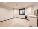 Finished basement area featuring carpet, white walls, natural light, and a small storage cabinet at 5390 S Geneva St, Englewood, CO 80111
