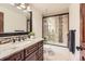 Bathroom featuring a modern vanity, stone countertop, decorative backsplash, and glass enclosed shower-tub combo at 5390 S Geneva St, Englewood, CO 80111