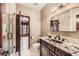Bathroom featuring granite countertop vanity, shower, toilet, and a view of the living room at 5390 S Geneva St, Englewood, CO 80111