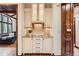 Butler pantry with granite countertops, glass-front cabinets, and a plant accent at 5390 S Geneva St, Englewood, CO 80111