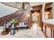 Elegant foyer featuring a staircase with wood paneling, tile floors, and a decorative bench at 5390 S Geneva St, Englewood, CO 80111