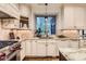 Well-lit kitchen with granite countertops, custom cabinets, and stainless steel appliances at 5390 S Geneva St, Englewood, CO 80111
