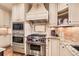 Gourmet kitchen with stainless steel appliances, custom cabinetry, and granite countertops at 5390 S Geneva St, Englewood, CO 80111
