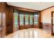 Bright living room featuring wood paneling, hardwood floors, and a large bay window with neighborhood views at 5390 S Geneva St, Englewood, CO 80111