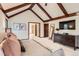 Main bedroom with vaulted ceilings, TV, dresser, and a view of the main bathroom at 5390 S Geneva St, Englewood, CO 80111