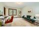 Bright home office with a green couch, desk, white shelving, carpet, and natural light at 5390 S Geneva St, Englewood, CO 80111