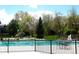 Community pool with fenced perimeter, lifeguard chair, lounge seating, and playset in the background at 5390 S Geneva St, Englewood, CO 80111