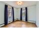 Cozy bedroom with parquet flooring, light blue walls, and curtains with natural light at 2022 S Clay St, Denver, CO 80219