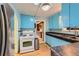 Functional kitchen featuring bright blue cabinets, a stainless steel refrigerator, and a gas range at 2022 S Clay St, Denver, CO 80219