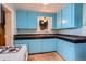 Well-lit kitchen showcasing blue cabinets, black countertops, and a vintage-style window above the sink at 2022 S Clay St, Denver, CO 80219