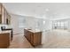 Open concept kitchen with island, modern appliances, and light wood cabinets at 144 Wooten Ave, Brighton, CO 80601