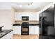 Modern kitchen with white cabinets, black appliances, granite countertops, and hardwood floors at 9019 E Panorama Cir # D211, Centennial, CO 80112