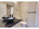 Bathroom featuring dark vessel sink, black hardware, and tile shower at 2902 W Long Cir # B, Littleton, CO 80120