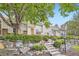 Inviting front exterior featuring tan siding, stone landscaping, green shrubs, and well-maintained stairs at 2902 W Long Cir # B, Littleton, CO 80120