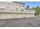 Townhome exterior with three garages, light siding, and well-maintained landscaping at 2902 W Long Cir # B, Littleton, CO 80120