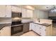 A kitchen featuring white cabinets, stainless steel appliances, and a view into the living room and fireplace at 2902 W Long Cir # B, Littleton, CO 80120