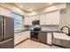 Well-equipped kitchen featuring stainless steel appliances, white cabinets, and tile flooring at 2902 W Long Cir # B, Littleton, CO 80120