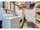 Unfinished basement area with washer, dryer, shelves, and storage space at 2902 W Long Cir # B, Littleton, CO 80120