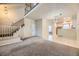 Spacious living room flowing into the dining area, featuring carpeted floors and a staircase at 2902 W Long Cir # B, Littleton, CO 80120