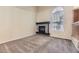 Cozy living room featuring a fireplace, neutral carpet, and natural light from a window at 2902 W Long Cir # B, Littleton, CO 80120