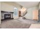 Open living space with fireplace, neutral carpet, and staircase leading to the upper level at 2902 W Long Cir # B, Littleton, CO 80120