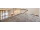 An upstairs loft area with carpeting, railing, and a view of the front entry at 2902 W Long Cir # B, Littleton, CO 80120