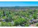 Scenic aerial view of a residential neighborhood with lush greenery, a cityscape skyline, and a water tower at 5610 Brentwood St, Arvada, CO 80002