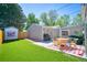 Backyard with artificial grass, a patio with seating, outdoor furniture, grill, and a shed at 5610 Brentwood St, Arvada, CO 80002