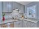 Close-up of a kitchen featuring sleek grey cabinets, granite countertops, and subway tile backsplash at 5610 Brentwood St, Arvada, CO 80002