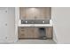 Modern wet bar with wood cabinets, gray tile backsplash, sink, and wine fridge at 4426 Utica St, Denver, CO 80212