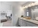 Bright bathroom featuring double sinks, granite countertop, and access to the bedroom at 26818 E 1St Pl, Aurora, CO 80018