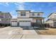 Charming two-story home with a three car garage, white siding, and stone accents at 26818 E 1St Pl, Aurora, CO 80018
