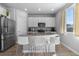 Modern kitchen featuring white cabinetry, granite countertops, and stainless steel appliances and eat-in island at 26818 E 1St Pl, Aurora, CO 80018