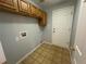 Laundry room with tile flooring, wooden cabinets, and modern hookups at 20148 E Dartmouth Dr, Aurora, CO 80013