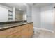 Modern bathroom featuring granite counters, wood cabinets, and a shower-tub combo at 1700 Bassett St # 1102, Denver, CO 80202