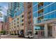 Condominium exterior with a mixture of brick, tan stone, and glass facades along a tree-lined street at 1700 Bassett St # 1102, Denver, CO 80202
