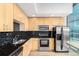 Modern kitchen featuring stainless steel appliances, blonde cabinets, and black subway tile backsplash at 1700 Bassett St # 1102, Denver, CO 80202