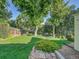 Well-maintained backyard with large trees, landscaping, and a stone-paved section near the house at 6844 S Detroit Cir, Centennial, CO 80122
