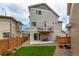 A manicured backyard shows the unit's siding, balcony, lawn and rock-covered garden at 10102 Yampa Ct, Commerce City, CO 80022