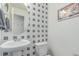 Chic powder room with modern fixtures, stylish mirror and unique wallpaper at 10102 Yampa Ct, Commerce City, CO 80022