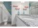 Modern bathroom with granite countertop, white cabinets, and stylish geometric wall design at 10102 Yampa Ct, Commerce City, CO 80022