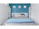 Charming bedroom with blue accent wall, built-in shelves, and natural light from square windows at 10102 Yampa Ct, Commerce City, CO 80022