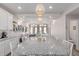 Open-concept dining area with a large island, stylish pendant lighting, and views of the living space at 10102 Yampa Ct, Commerce City, CO 80022