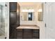 Bathroom features dark cabinets, granite countertops and shower with glass doors and tile at 11181 W Crestline Dr, Littleton, CO 80127