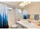 Bathroom with white tile, vanity and shower-tub combo with decorative curtain at 11181 W Crestline Dr, Littleton, CO 80127